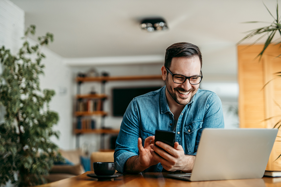 person using a phone and laptop