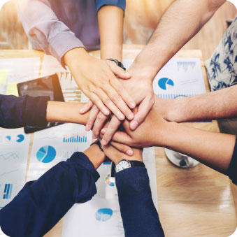 Hands stacked in a team huddle over performance charts, representing SC Network Solutions Managed IT in Southern Utah.